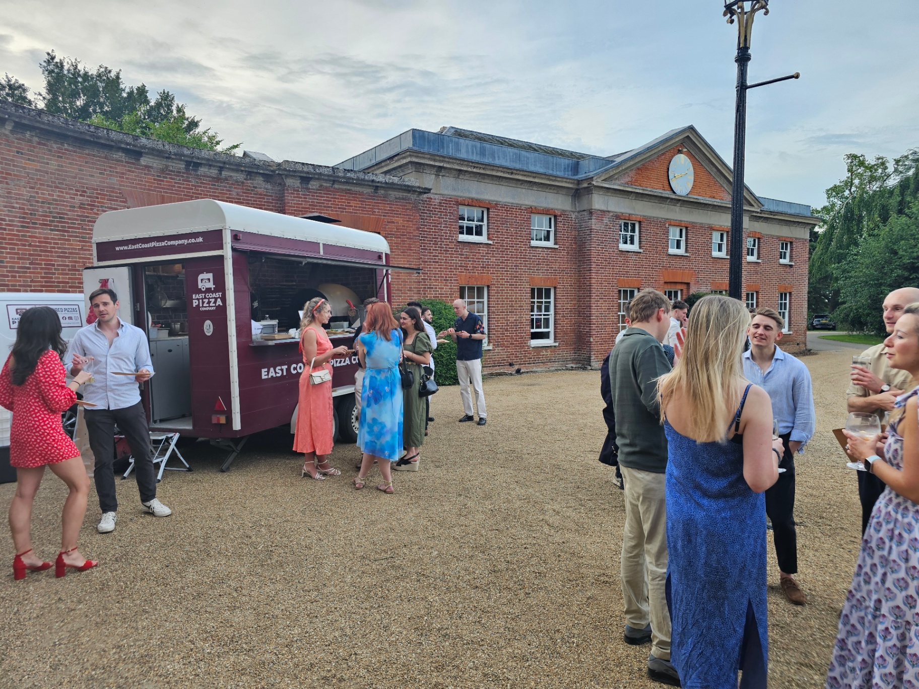 Smartly-dressed guests gathered around the Nag Box in a Georgian manor courtyard at a private party